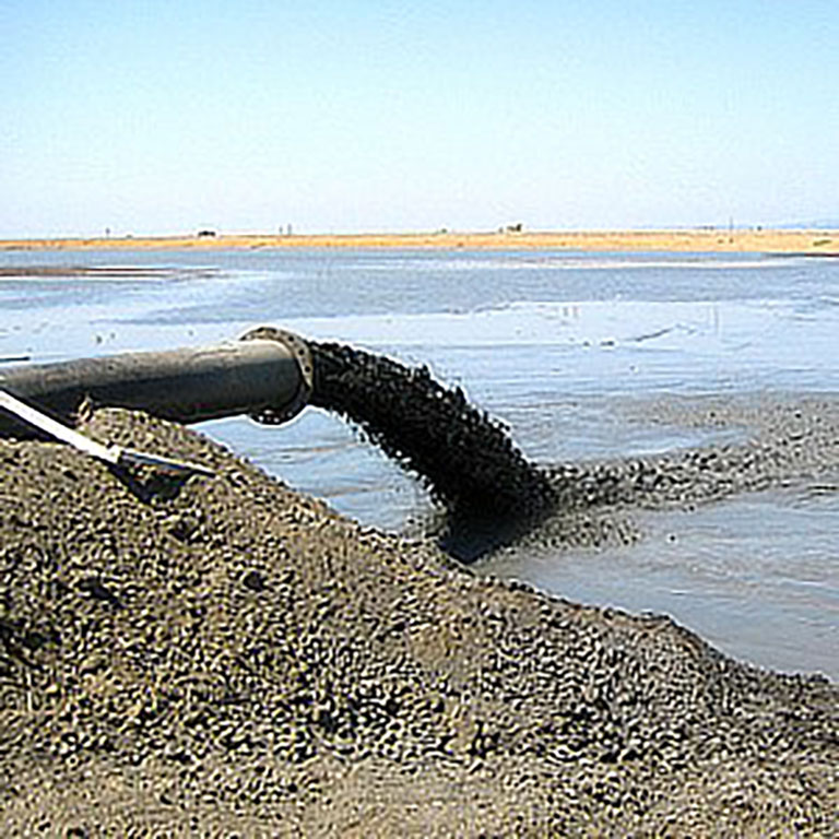 A pipe discharging water into a pond